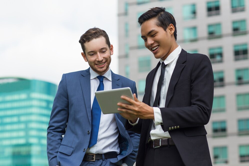 closeup smiling coworkers using tablet outdoors 1262 3493
